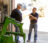 Two men standing in the garage door of a shop with farm equipment having a conversation